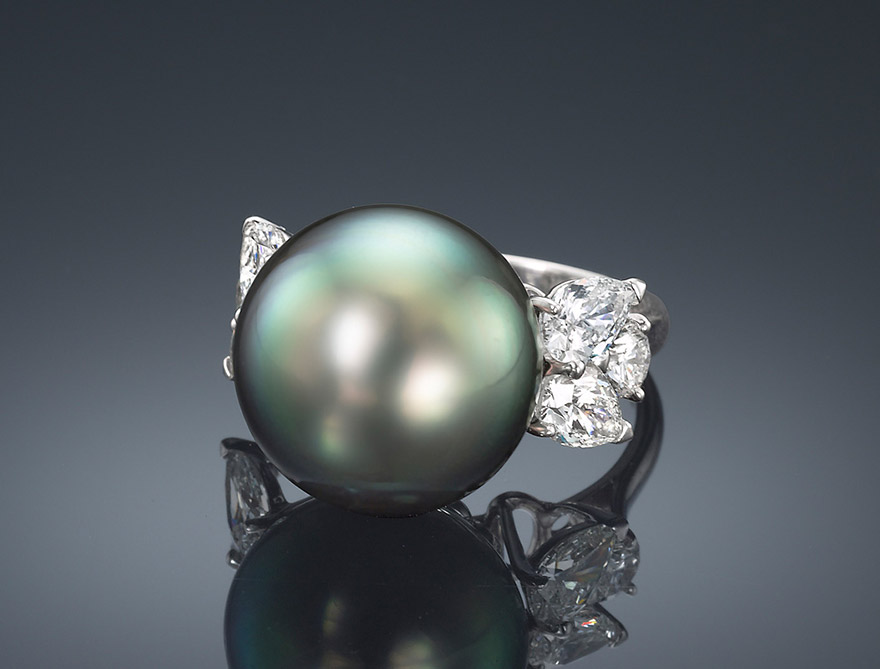 Tahitian Cultured Pearl and Diamond Ring Full-cut round and pear-shaped diamonds highlight the luster and iridescent orient of this stunning Natural Color Tahitian Cultured Pearl. Hand set in 18K white gold.