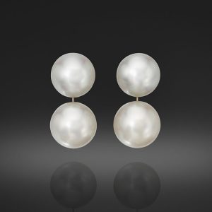 A Pair of South Sea Cultured Pearl Buttons, approximately 15 X 12mm, and a Pair of Round South Sea Cultured Pearls, 16.5mm, set in Platinum with Post backs.