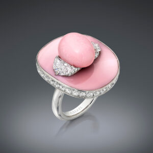 A rare Natural Saltwater Conch Pearl is flanked by a Pair of Half-Moon Diamonds totaling